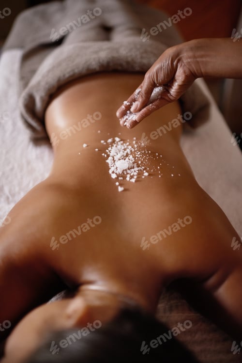 Preview: Lightly salted...Shot of a young woman enjoying a salt exfoliation treatment at a spa.