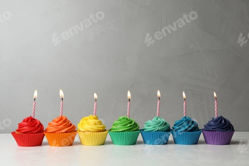 Preview: Delicious birthday cupcakes with burning candles on table