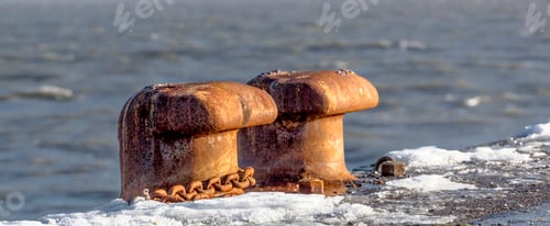Preview: Closeup of two old rusty bollards in the sea