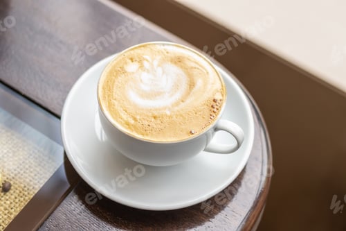 Preview: White Cup of Cappuccino with fine crema on wooden table in coffee shop