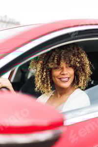 Preview: Afro-Dominican Girl in red car, vertical shot, smiling face