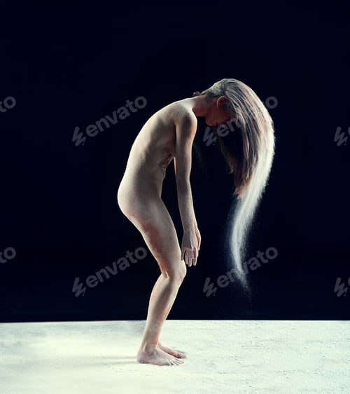 Preview: Studio shot of a young woman leaving a trail of powder in the air by whipping her hair