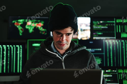 Preview: Concentrated hacker man, programmer or developer typing software code on a laptop computer at