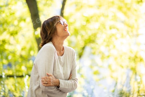 Preview: carefree older woman laughing in park