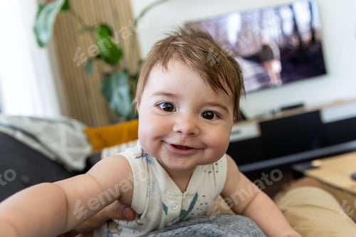 Preview: Smiling happy baby boy making selfie by own hand