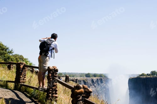 Preview: Mid adult man photographing Victoria Falls, Zambia