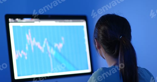 Preview: Woman study on stock market data at night
