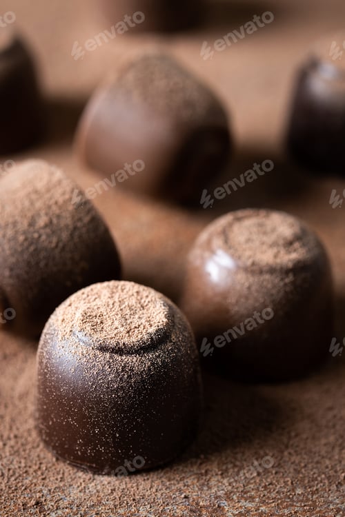 Preview: Chocolate bonbons and cocoa powder background
