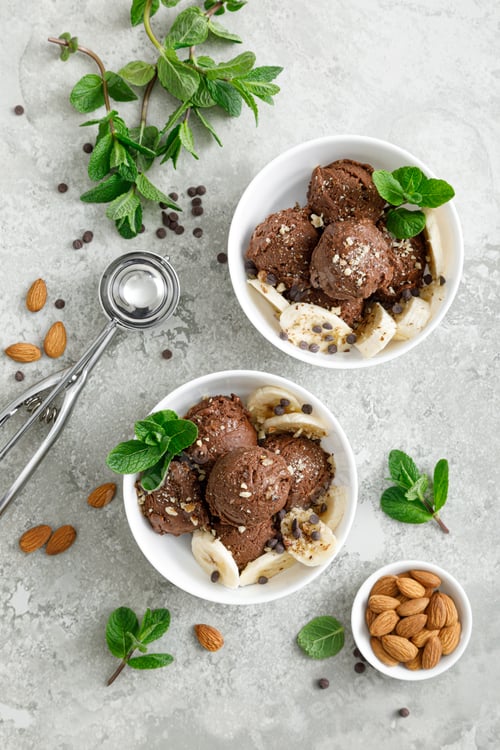 Preview: Chocolate and banana fruit ice cream with almond nuts served in bowls, top view