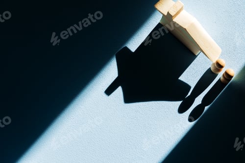 Preview: Miniature wooden house with shadows on blue background