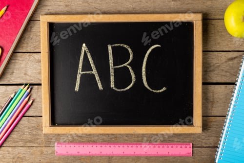 Preview: Composition of blackboard with abc and school items on wooden background