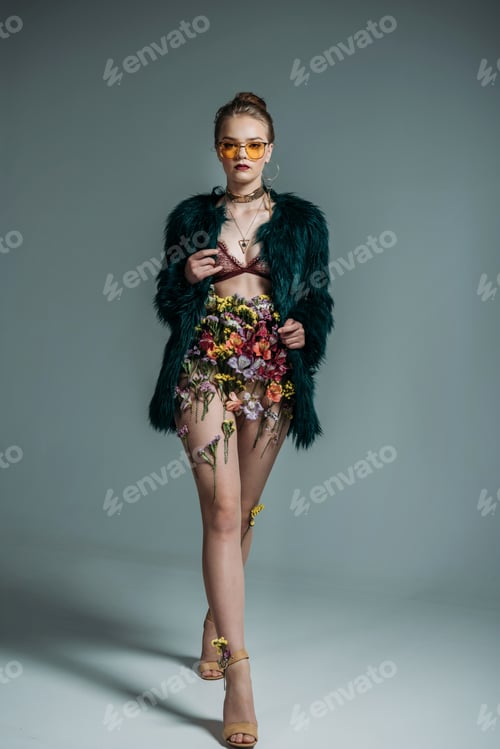Preview: young attractive model posing in floral skirt, lace bra and green fur coat for fashion shoot on