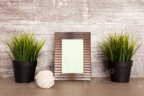 Preview: Old photo frame next to two pots with grass
