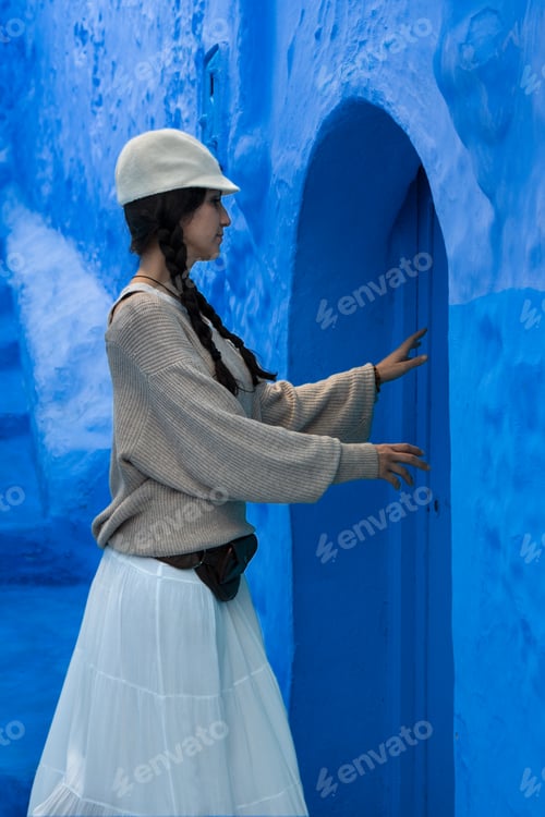 Preview: Young woman opening blue door