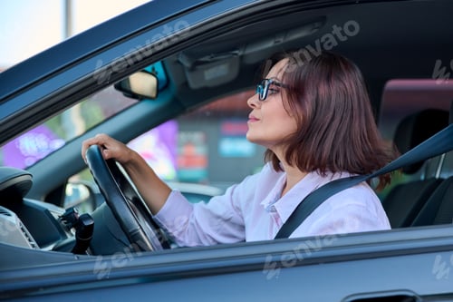 Preview: Middle-aged beautiful woman driver driving a car