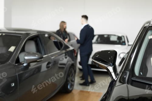 Preview: A couple of friends of girls with a car dealer choose a car in a car dealership