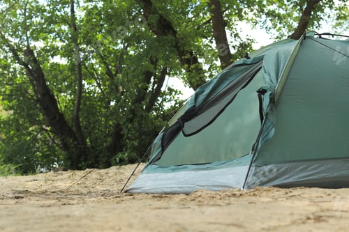 Preview: Modern camping tent near trees in wilderness