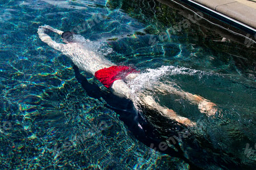 Preview: Man underwater after diving into swimming pool.