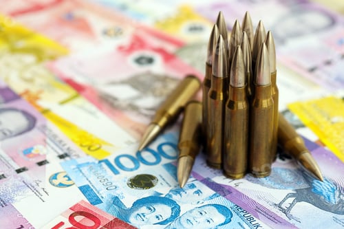 Preview: Philippines peso currency money bills and rifle bullets. The concept of warfare and gun selling