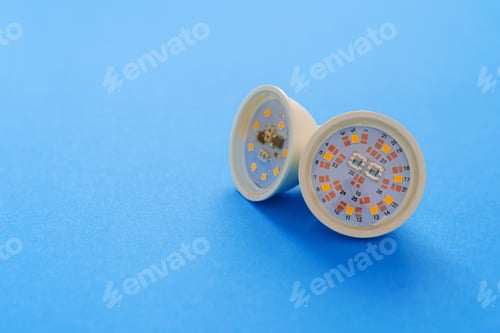 Preview: Light bulbs on blue paper background close up