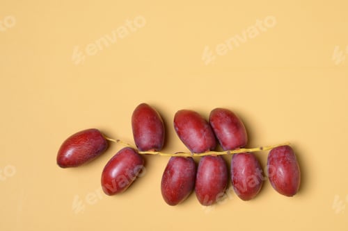 Preview: Fresh red date palms on yellow background