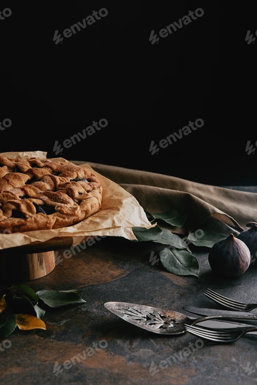 Preview: close up view of homemade pie on cake stand on grungy tabletop with black background