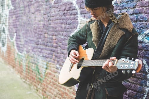 Preview: Musician playing guitar by canal wall, Milan, Italy