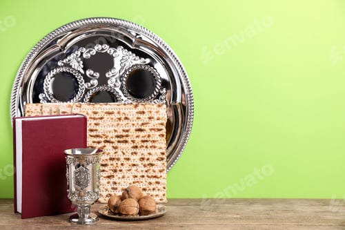 Preview: Symbolic Pesach (Passover Seder) items on wooden table against green background, space for text
