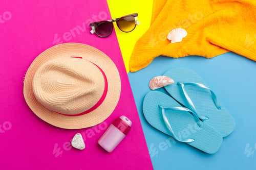 Preview: Bright beach items arranged on vibrant colored background for summer fun