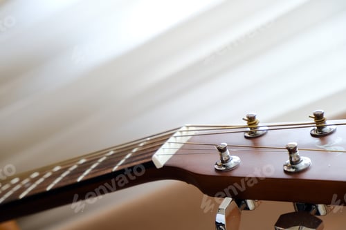 Preview: Guitar fretboard, strings and frets. Stringed musical instrument. The guitar stands on a chair.