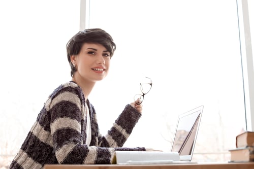 Preview: Young woman working with laptop at desk. Home office