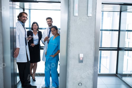 Preview: Doctors and businesswoman standing in elevator