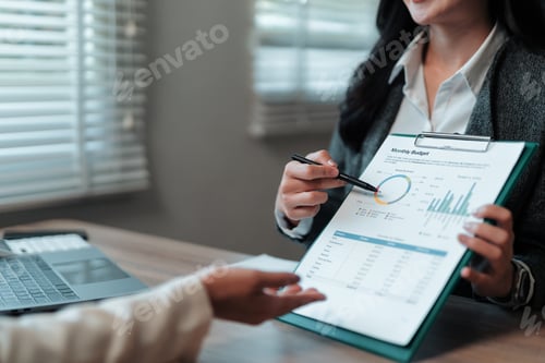 Preview: Businesswoman pointing at monthly budget showing positive results