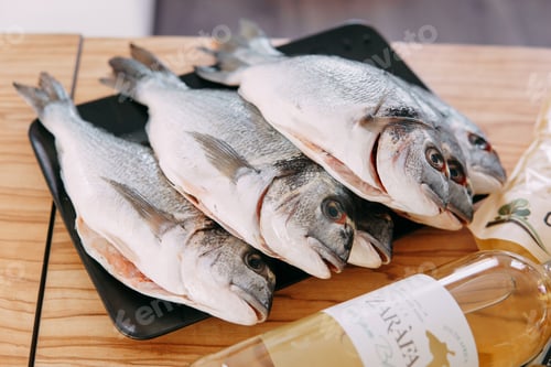 Preview: Raw Dorado fish on a black plate. Cooking Dorado in a cooking class. Raw fish, close-up.