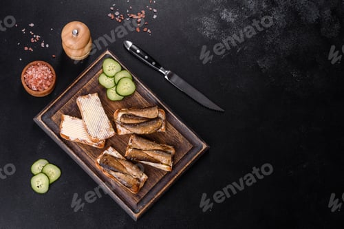 Preview: Delicious fresh sandwich with sprats with crispy toast, butter and cucumber