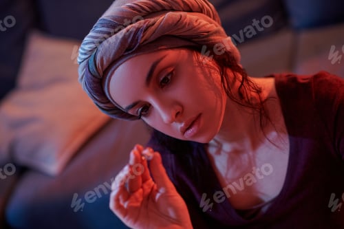 Preview: Serious lady scrutinizing a gemstone in her hand