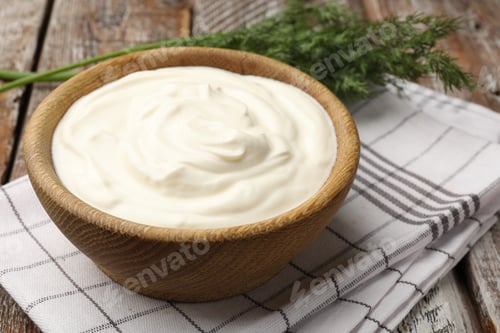 Preview: Tasty sour cream with dill on wooden table, closeup