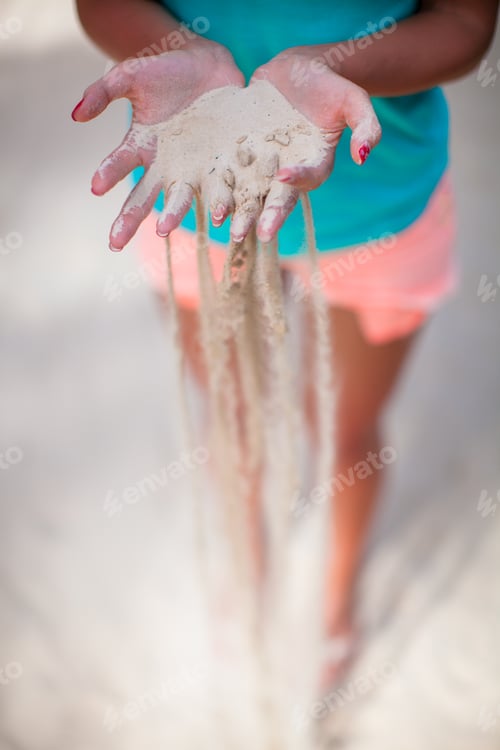 Preview: White sand through the fingers of the young girl
