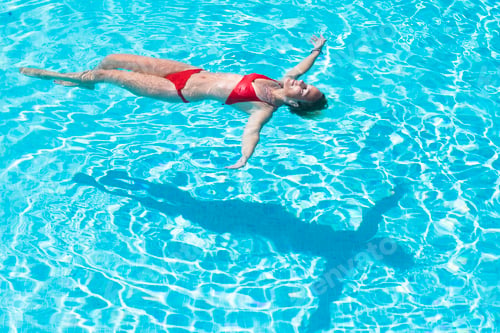 Preview: Young caucasian woman relax and enjoy summer holiday vacation floating laying on the water pool
