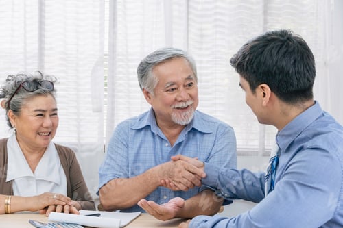 Preview: Asian senior man handshaking with agent after closing deal