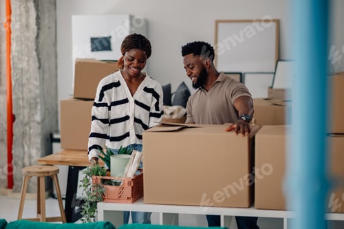 Preview: Happy couple unpacking cardboard boxes in new home