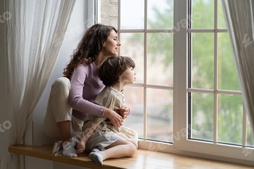 Preview: Mom and curious kid look outside sit on window sill. Mother or babysitter exploring world from home