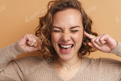 Preview: Young ginger woman laughing and plugging her ears