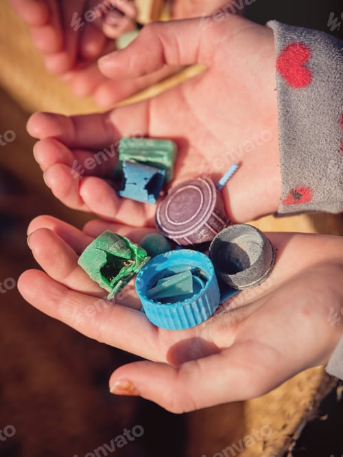 Preview: Anonymous children hands with pieces of plastic