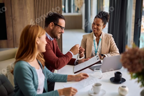 Preview: Happy black insurance agent signing a contract with her clients during a meeting.