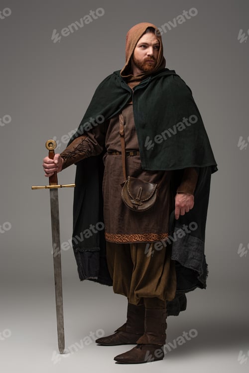 Preview: medieval Scottish redhead knight in mantel with sword on grey background
