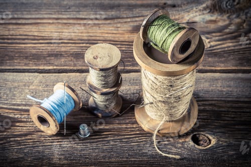 Preview: Needles and threads in tailor workshop on wooden background