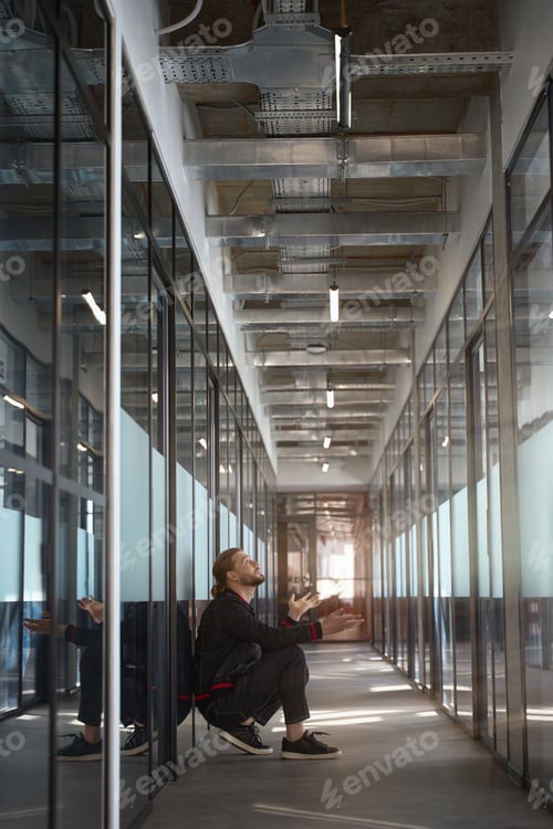 Preview: Diligent male looking up in corridor of office