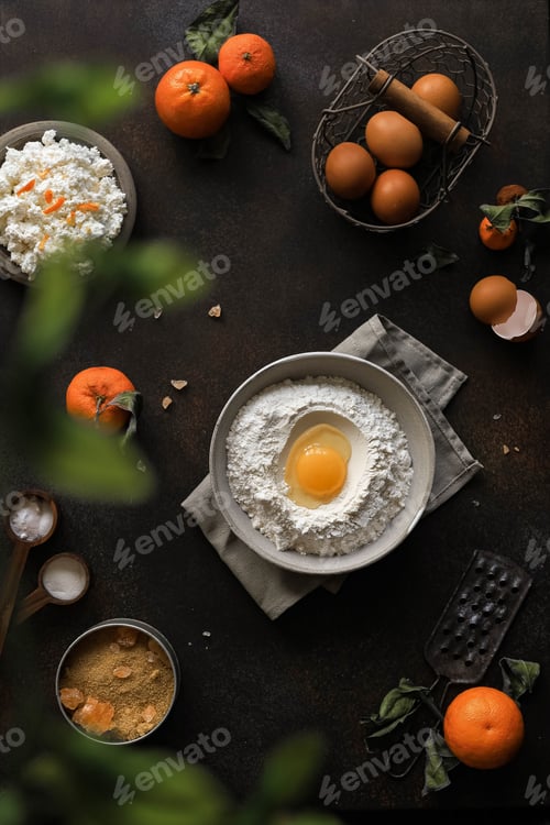 Preview: Top view of a table with ingredients for cooking sweet homemade pastries with orange.