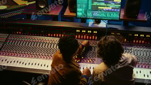 Preview: Sound Engineers Working on Mixing Console in Studio